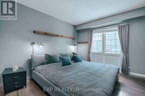 Clarington (Bowmanville) condo for rent - A bedroom with a bed, nightstand, and window.