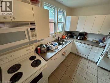 Hamilton apartment for rent - A kitchen with white appliances and a black stove top.