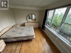 Hamilton apartment for rent - A bedroom with a bed, dresser, and mirror.