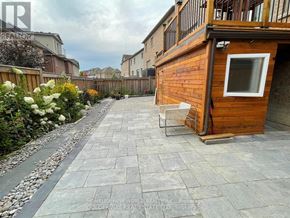 Newmarket (Stonehaven-Wyndham) apartment for rent - A backyard with a wooden deck and a stone patio.