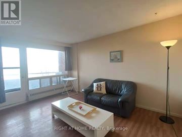 Ottawa condo for rent - A living room with a black leather couch and a white coffee table.