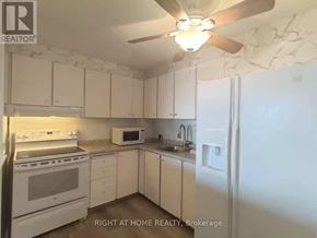 Ottawa condo for rent - A kitchen with white appliances and cabinets.