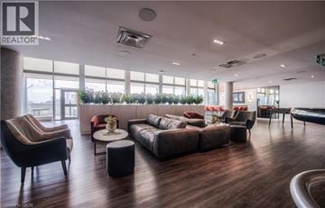 Kitchener condo for rent - A living room with a brown sofa and a black armchair.