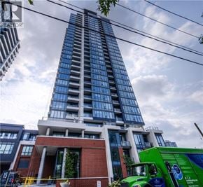 Kitchener condo for rent - A tall building with a green truck parked in front of it.