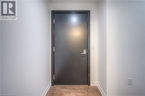 Kitchener condo for rent - A black door with a silver handle is in a white room.