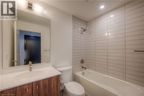 Kitchener condo for rent - A white bathroom with a sink, toilet, and bathtub.