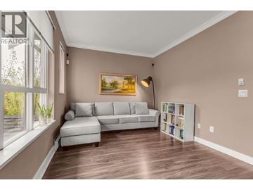 Coquitlam townhouse for rent - A living room with a grey couch and a painting on the wall.