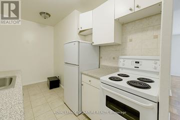 Toronto (Yonge-Eglinton) house for rent - A white kitchen with a stove and a refrigerator.