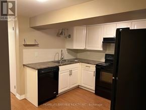 Aurora (Aurora Heights) apartment for rent - A kitchen with white cabinets and a black refrigerator.