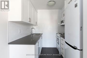 Toronto (Yonge-Eglinton) condo for rent - A kitchen with white cabinets and a black counter top.