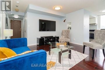 Mississauga (Cooksville) condo for rent - A blue couch sits in a living room with a glass coffee table in front of it.