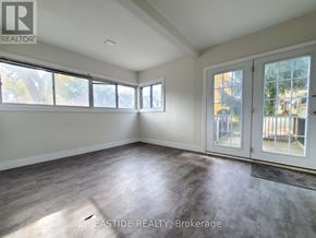 Toronto (Danforth) apartment for rent - A sunny room with a slanted ceiling and a door leading to a balcony.