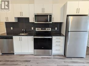 Waterloo condo for rent - A kitchen with white cabinets and a black countertop.