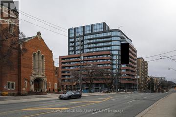 Toronto (Forest Hill North) condo for rent - A car is driving down a street past a church and a large building.