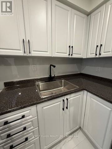 Toronto (Kensington-Chinatown) apartment for rent - A kitchen with white cabinets and a granite countertop.