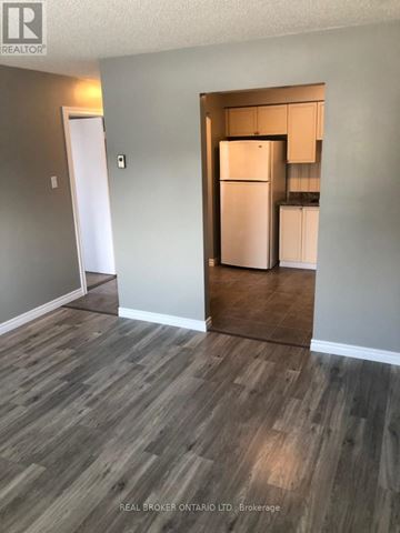 Barrie (Ardagh) condo for rent - A kitchen area with a refrigerator and cabinets.