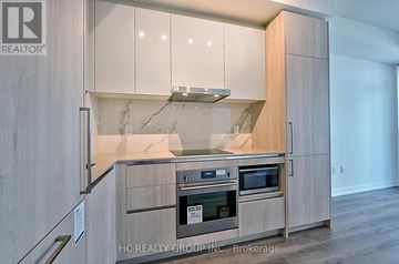Vaughan (Vaughan Corporate Centre) condo for rent - A modern kitchen with wooden cabinets and stainless steel appliances.