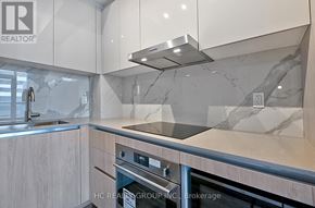 Vaughan (Vaughan Corporate Centre) condo for rent - A modern kitchen with a stainless steel oven and a marble backsplash.