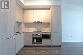 Vaughan (Vaughan Corporate Centre) condo for rent - A modern kitchen with wooden cabinets and a built-in oven.