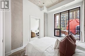 Ottawa condo for rent - A bedroom with a large bed and a view of the city.