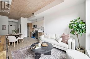 Ottawa condo for rent - A modern living room with a white sofa, a wooden coffee table, and a dining table with chairs.