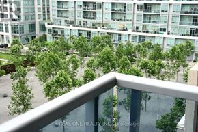 Toronto (North St. James Town) condo for rent - A balcony overlooks a courtyard with trees and a building in the background.