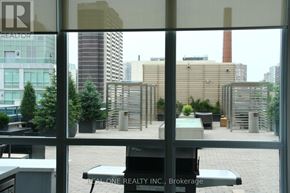 Toronto (North St. James Town) condo for rent - A view of a cityscape through a window with a Real One Realty Inc. sign in the foreground.