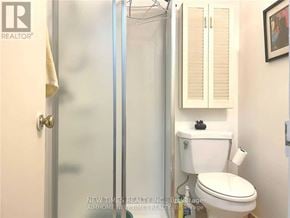Toronto (Bayview Woods-Steeles) apartment for rent - A white toilet in a bathroom with a glass shower door.
