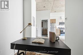 Ottawa condo for rent - A desk with a lamp and a book on it in a room.