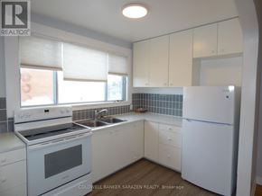 Ottawa apartment for rent - A white kitchen with a refrigerator, stove, and sink.
