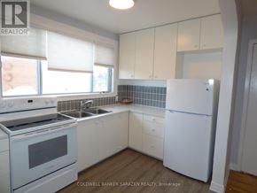 Ottawa apartment for rent - A kitchen with white appliances and cabinets.