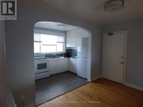 Ottawa apartment for rent - A kitchen with white cabinets and a person in the background.