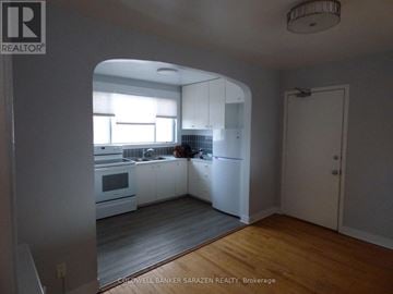 Ottawa apartment for rent - A kitchen with white cabinets and a person in the background.