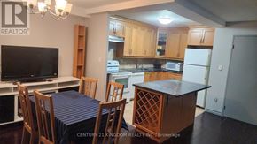 Toronto (Flemingdon Park) condo for rent - A kitchen with wooden cabinets and a dining table with chairs.