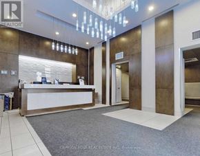 Toronto (Mimico) condo for rent - A reception area with a white counter and a chandelier hanging from the ceiling.