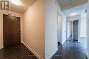 Toronto (Mimico) condo for rent - A hallway with a wooden door and a white wall.