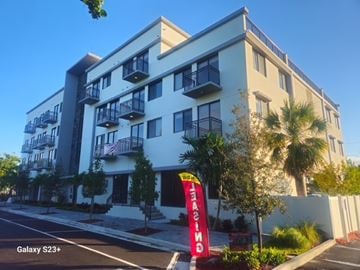 Pompano Beach apartment for rent - A tall white building with balconies and a red sign that says "GALAXY S23+".