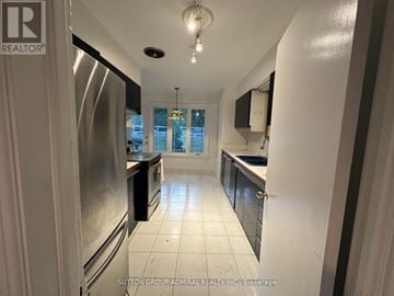 Toronto (Edenbridge-Humber Valley) apartment for rent - A kitchen with white tiled floors and a stainless steel refrigerator.