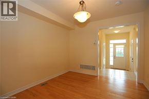 Kitchener townhouse for rent - A room with a wooden floor and a light hanging from the ceiling.