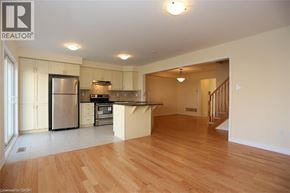Kitchener townhouse for rent - A kitchen with a refrigerator, microwave, and oven.