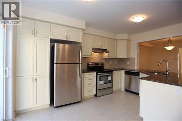 Kitchener townhouse for rent - A kitchen with white cabinets and a stainless steel refrigerator.