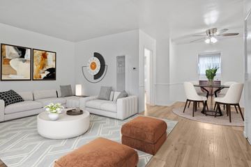 Glendale apartment for rent - A living room with a white couch, a round coffee table, and a dining table with chairs.