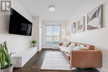 Toronto (Bayview Village) condo for rent - A living room with a brown couch and a flat screen TV mounted on the wall.