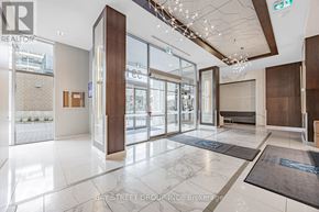 Toronto (Bayview Village) condo for rent - The image shows the lobby of a building with a glass wall and a brown door.