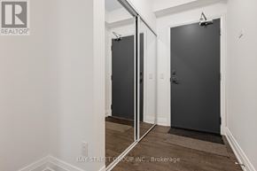Toronto (Bayview Village) condo for rent - A hallway with a door and a mirror on the wall.