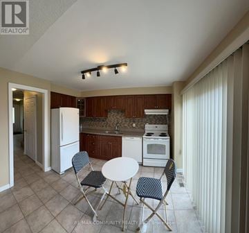 Ajax (South East) apartment for rent - A kitchen with a table and chairs in the foreground.