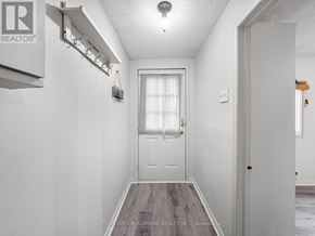 Toronto (Oakridge) apartment for rent - A hallway with a white door and a light on the ceiling.