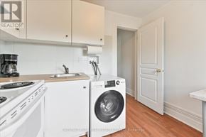 Toronto (Roncesvalles) townhouse for rent - A white washing machine is in a kitchen with white cabinets.