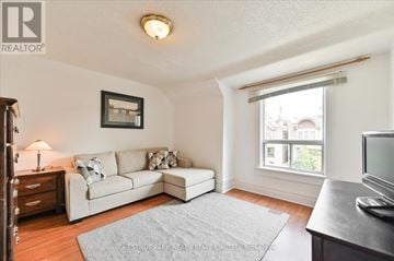 Toronto (Roncesvalles) townhouse for rent - A living room with a white couch and a grey rug.
