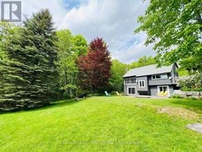 Georgian Bay (Baxter) apartment for rent - A house with a grey roof and a green lawn in front of it.